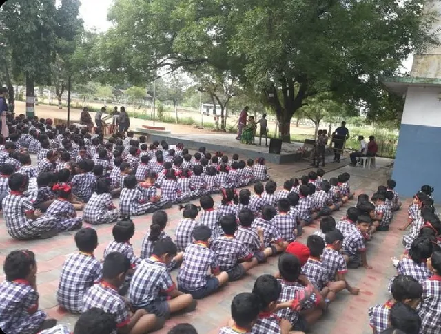 Students seated at an assembly for a prayer song workshop